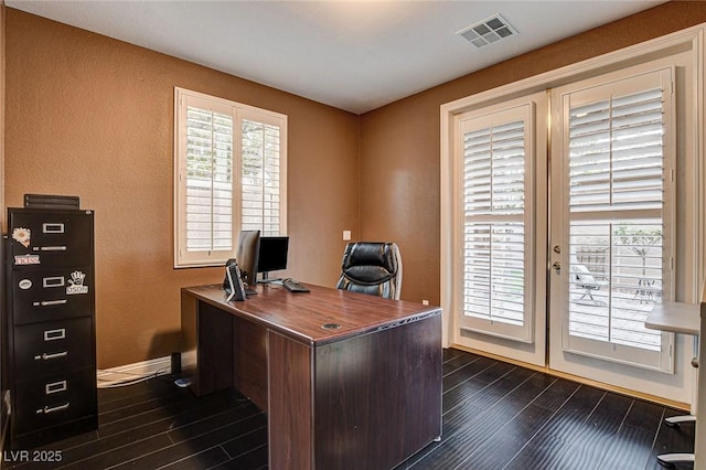 office with visible vents, dark wood finished floors, a textured wall, and baseboards