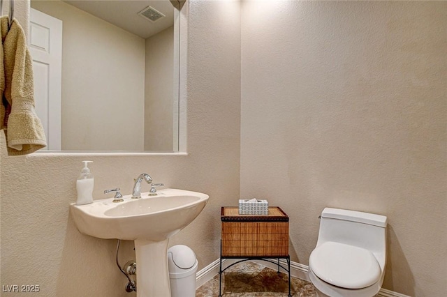 bathroom featuring toilet, baseboards, and visible vents