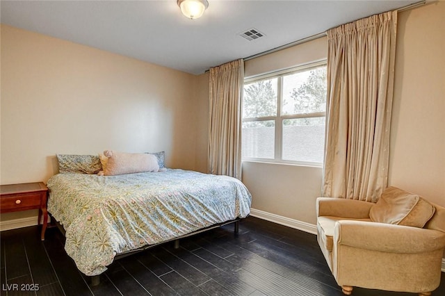 bedroom featuring baseboards, dark wood-type flooring, and visible vents