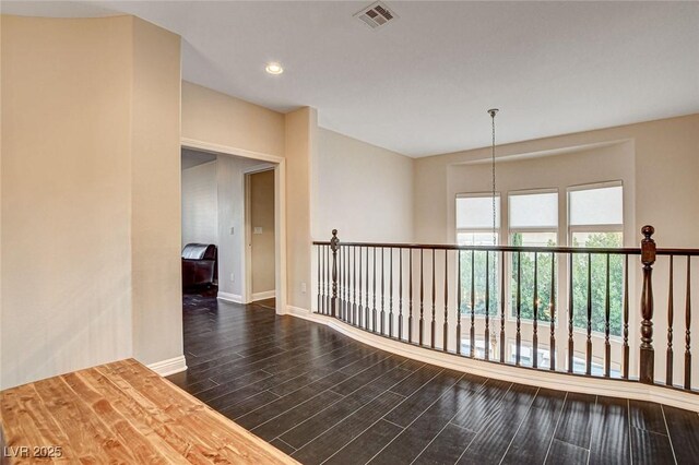 corridor featuring baseboards, recessed lighting, wood finished floors, and visible vents