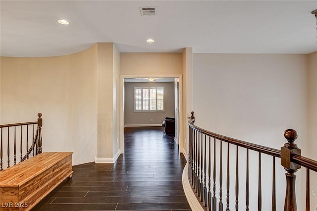 corridor featuring visible vents, recessed lighting, dark wood-style flooring, and an upstairs landing