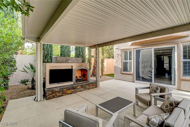 view of patio featuring fence and an outdoor living space with a fireplace