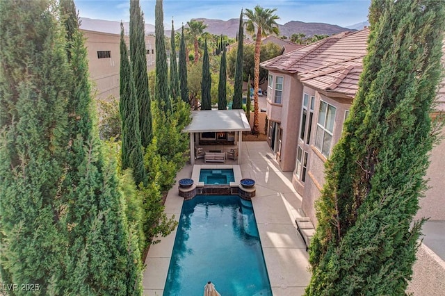 pool featuring an in ground hot tub and a patio area