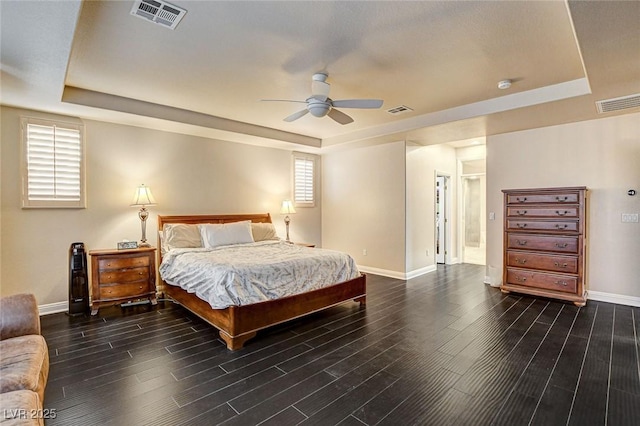 bedroom featuring baseboards, visible vents, and a raised ceiling