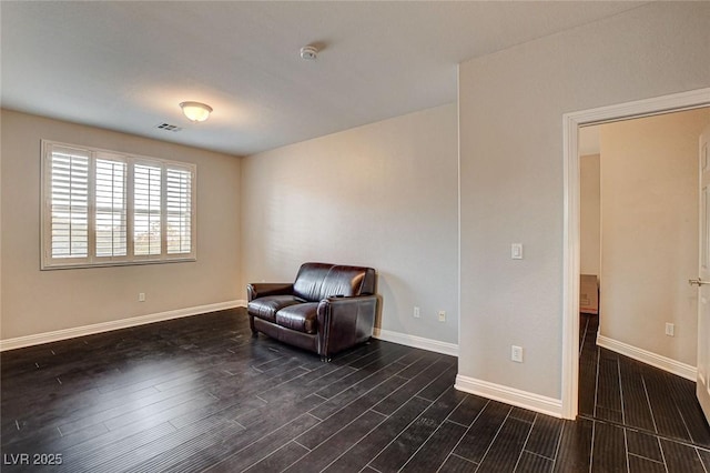 living area with baseboards, dark wood-type flooring, and visible vents