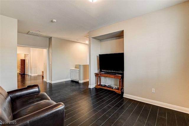 living area with baseboards, wood finished floors, and visible vents