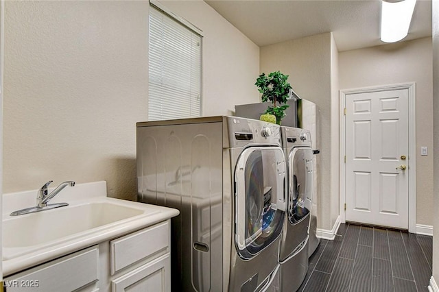 laundry area featuring laundry area, a sink, baseboards, and independent washer and dryer