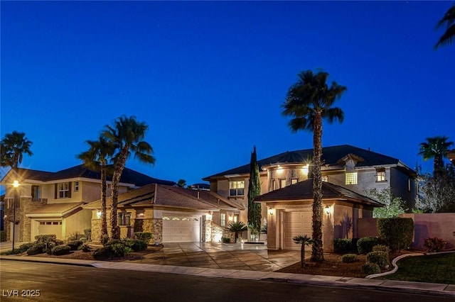 view of front of property with stucco siding, driveway, and a garage