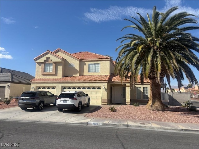 view of front of property with stucco siding, fence, an attached garage, a tiled roof, and driveway