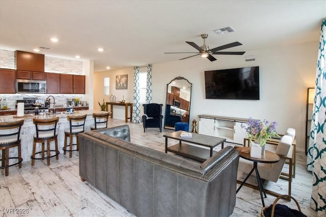living area featuring a ceiling fan and recessed lighting