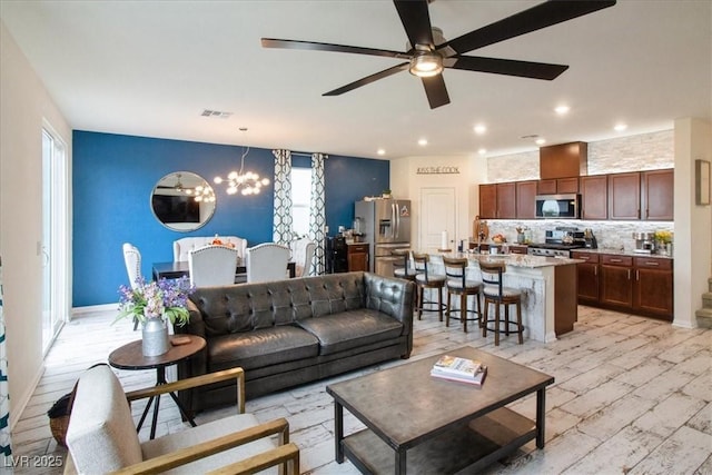 living area with ceiling fan, a chandelier, recessed lighting, and light wood-style floors