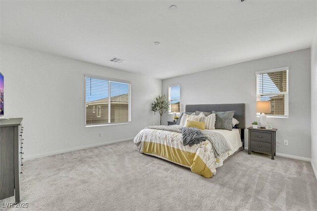 carpeted bedroom with baseboards, multiple windows, and visible vents