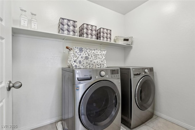 laundry area featuring light tile patterned floors, washing machine and dryer, laundry area, and baseboards