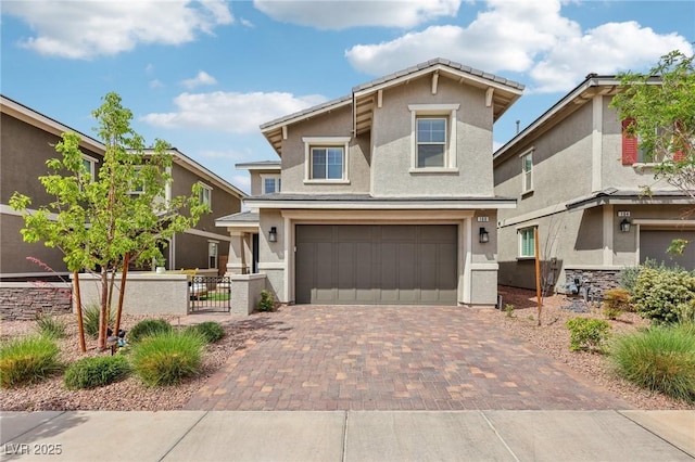 craftsman inspired home featuring a garage, stucco siding, fence, and decorative driveway