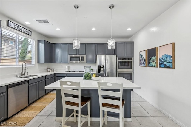 kitchen with light tile patterned floors, light countertops, visible vents, stainless steel appliances, and a sink