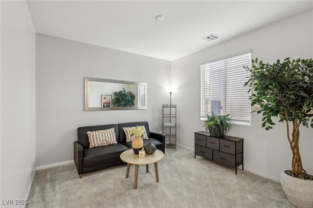 living area with baseboards, visible vents, and carpet floors