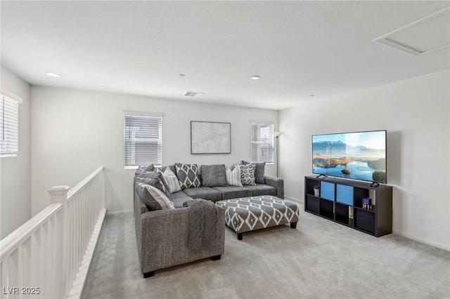 carpeted living room with attic access, visible vents, and recessed lighting