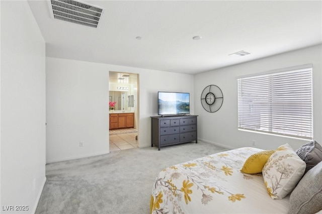 carpeted bedroom featuring baseboards, visible vents, and connected bathroom