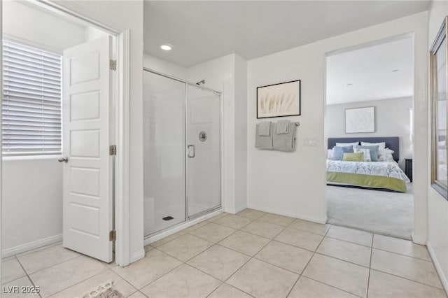 bathroom featuring tile patterned floors, ensuite bath, a stall shower, and baseboards