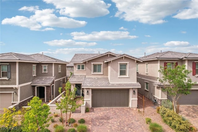 view of front of house with a residential view, stucco siding, decorative driveway, and an attached garage