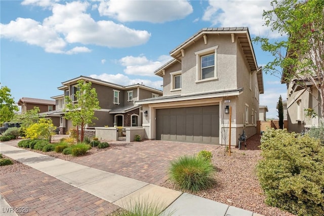 view of front of home featuring fence, decorative driveway, a garage, and stucco siding