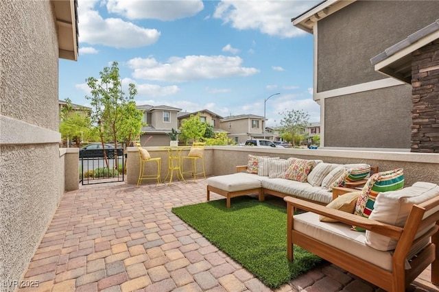 view of patio with an outdoor hangout area, fence, and a residential view