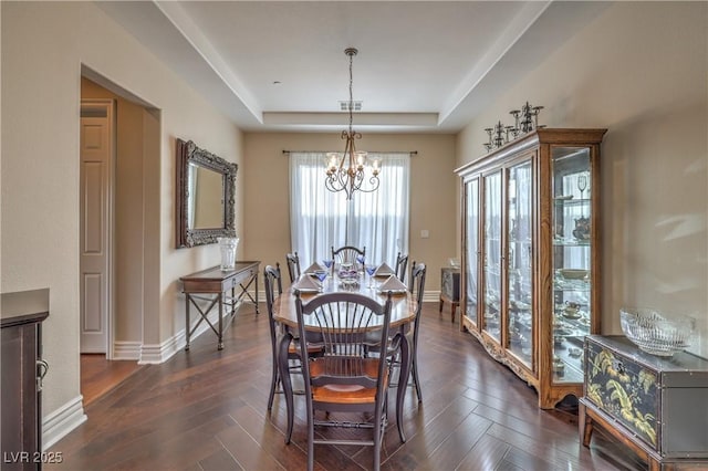 79 Rezzonico Dr, Henderson, NV 89011 - dining area with a raised ceiling, a chandelier, baseboards, and dark wood-type flooring
