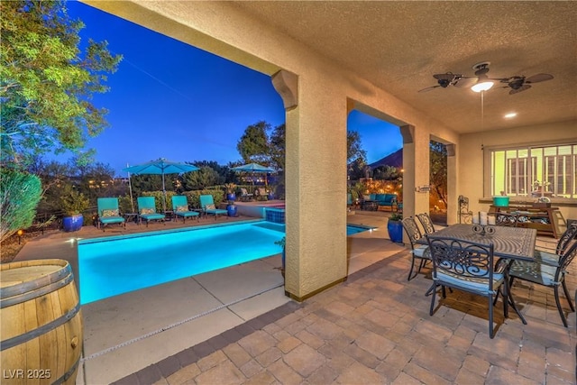 79 Rezzonico Dr, Henderson, NV 89011 - pool at night with ceiling fan, a patio area, and an outdoor hot tub