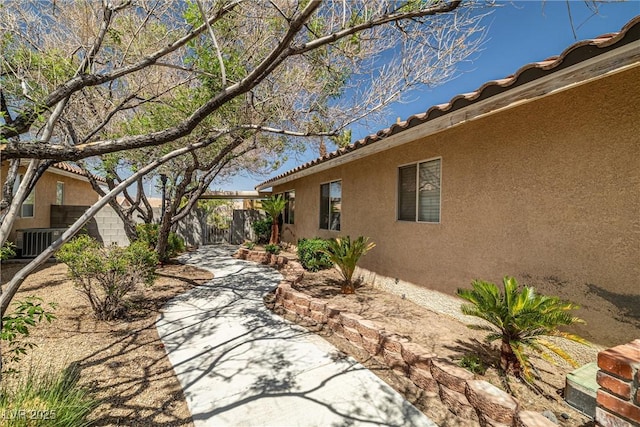388 Coronado Dr, Henderson, NV 89015 - view of side of home with stucco siding, a fenced backyard, a patio area, central air condition unit, and a tiled roof