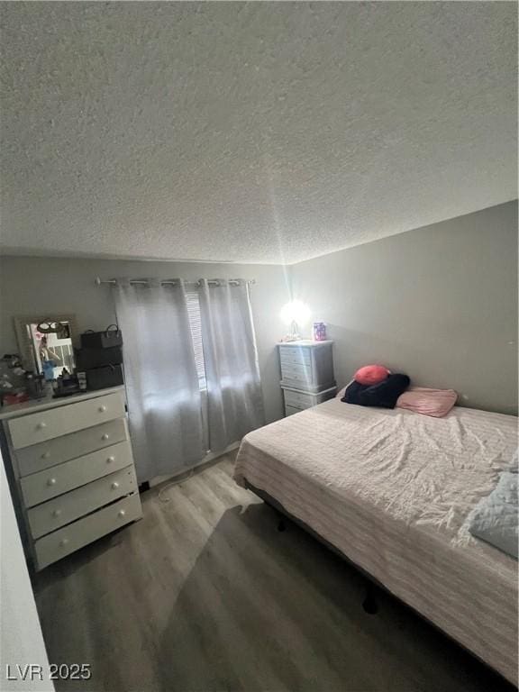 bedroom featuring light wood-style flooring and a textured ceiling
