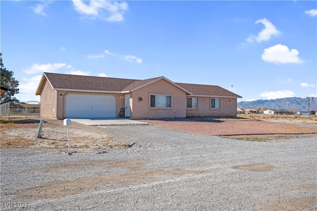 2831 Goldrush St, Pahrump, NV 89048 - view of front of house with driveway, stucco siding, an attached garage, and a mountain view