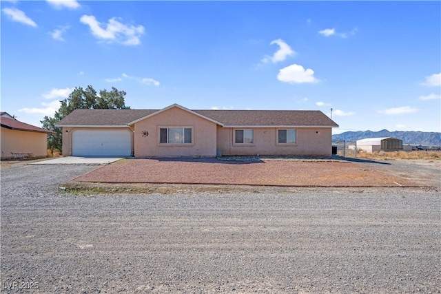 2831 Goldrush St, Pahrump, NV 89048 - ranch-style home featuring gravel driveway, a garage, stucco siding, and a mountain view