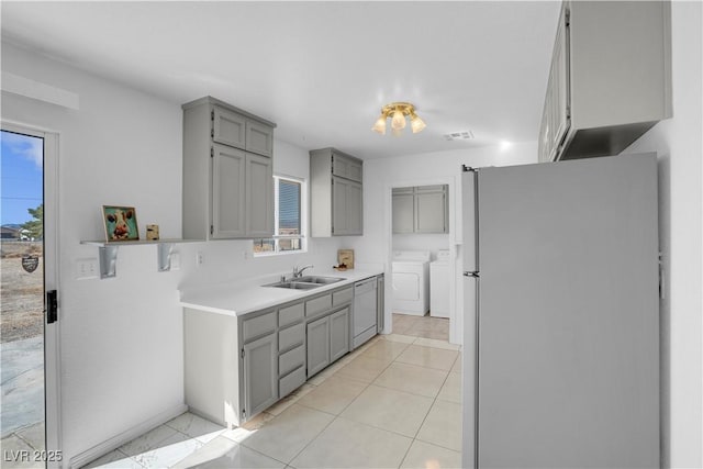 2831 Goldrush St, Pahrump, NV 89048 - kitchen featuring a sink, freestanding refrigerator, gray cabinetry, white dishwasher, and washer and dryer