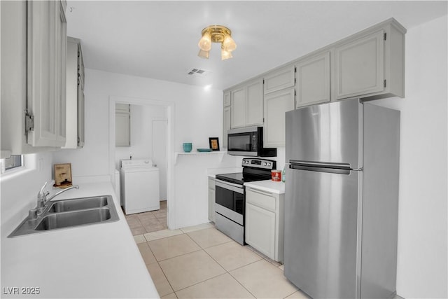 2831 Goldrush St, Pahrump, NV 89048 - kitchen with light tile patterned floors, stainless steel appliances, a sink, washer / clothes dryer, and visible vents