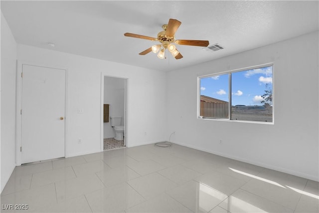 2831 Goldrush St, Pahrump, NV 89048 - unfurnished bedroom featuring tile patterned floors, ensuite bath, baseboards, visible vents, and ceiling fan