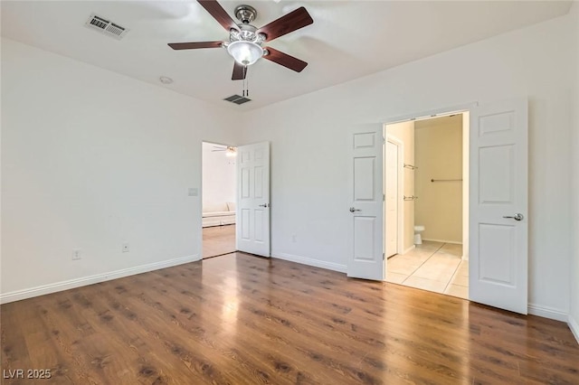 2409 Garganey Ave, North Las Vegas, NV 89084 - unfurnished bedroom featuring connected bathroom, wood finished floors, and baseboards