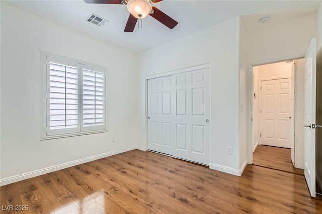 2409 Garganey Ave, North Las Vegas, NV 89084 - unfurnished bedroom with wood finished floors, a closet, baseboards, and ceiling fan