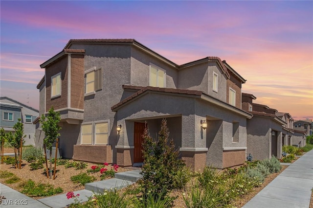 view of front of house with a tiled roof and stucco siding