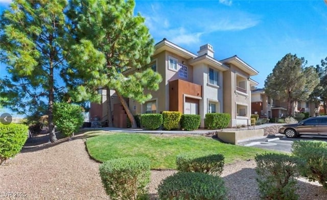 1012 Domnus Ln Unit 105, Las Vegas, NV 89144 - view of side of property with stucco siding, a chimney, and a lawn
