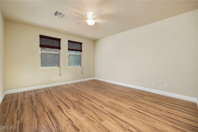 unfurnished room featuring ceiling fan, visible vents, baseboards, and light wood finished floors