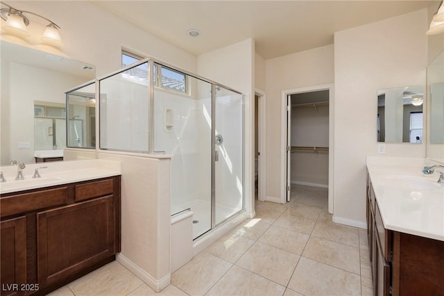 full bathroom with a sink, a shower stall, and two vanities