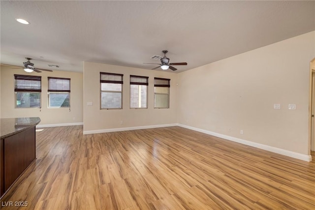 unfurnished living room with light wood-style floors, baseboards, and ceiling fan