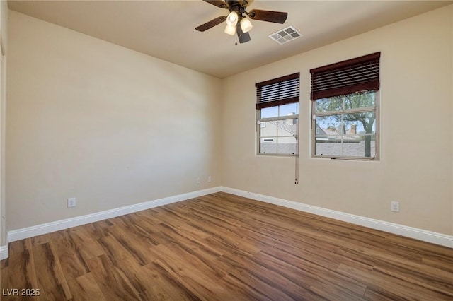 unfurnished room featuring baseboards, a ceiling fan, wood finished floors, and visible vents