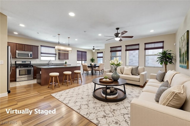 living room featuring recessed lighting, light wood finished floors, and a wealth of natural light