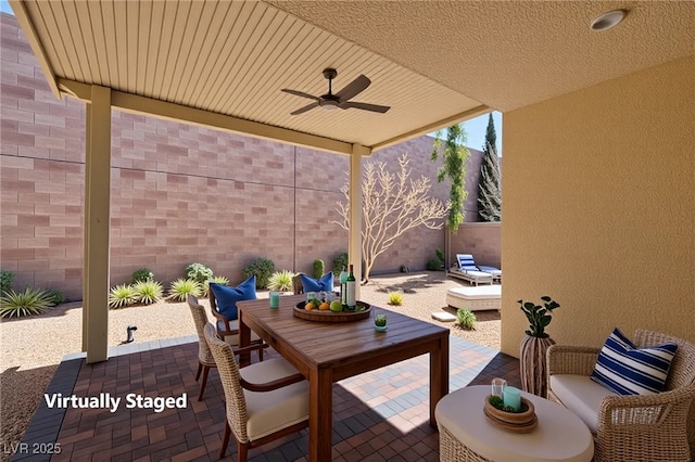 view of patio featuring a ceiling fan, outdoor dining space, and a fenced backyard