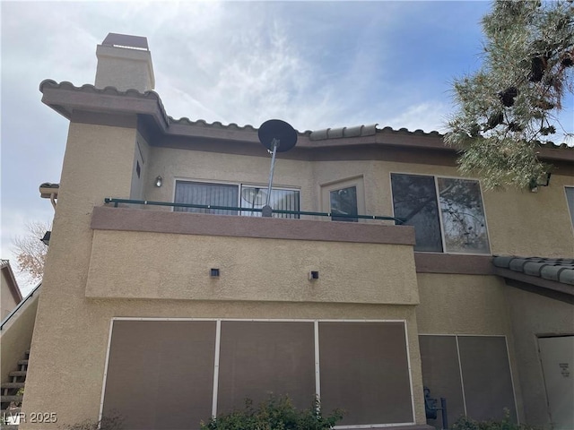 5710 E Tropicana Ave Unit 2033, Las Vegas, NV 89122 - back of house featuring a balcony, stucco siding, and an attached garage