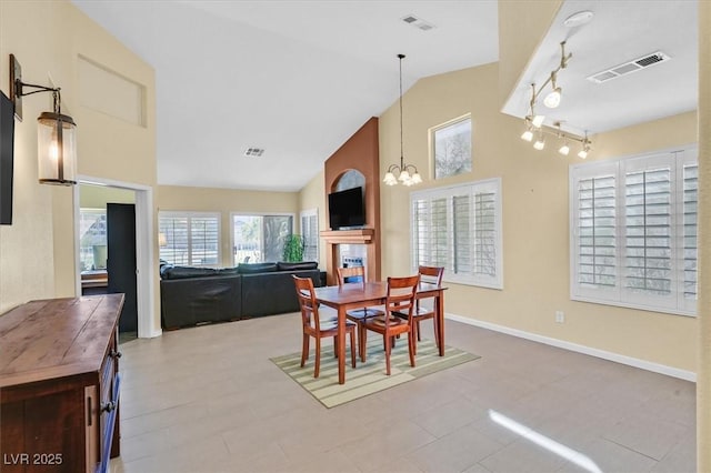4932 Forest Oaks Dr, Las Vegas, NV 89149 - dining room featuring a chandelier, high vaulted ceiling, rail lighting, and a tile fireplace