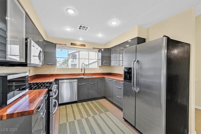 4932 Forest Oaks Dr, Las Vegas, NV 89149 - kitchen with wooden counters, stainless steel appliances, gray cabinetry, and recessed lighting