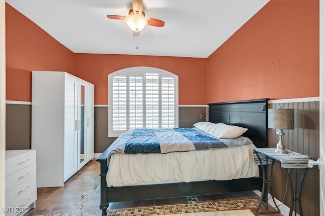 4932 Forest Oaks Dr, Las Vegas, NV 89149 - bedroom with wainscoting, lofted ceiling, and a ceiling fan