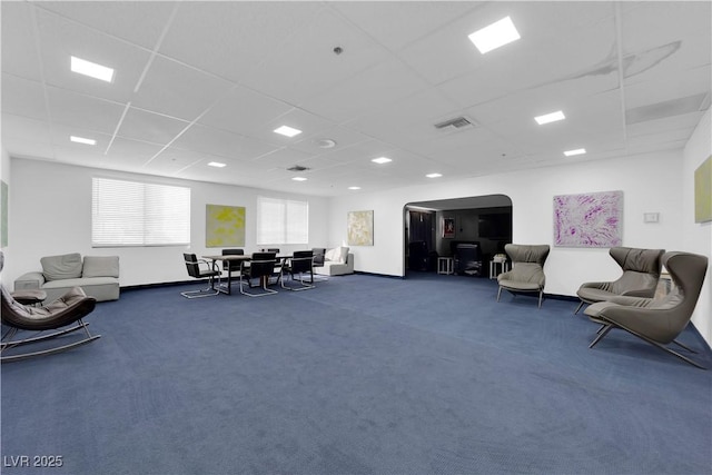 miscellaneous room with arched walkways, visible vents, a drop ceiling, and carpet